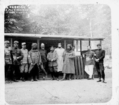 Soldats posant devant une cabane en bois