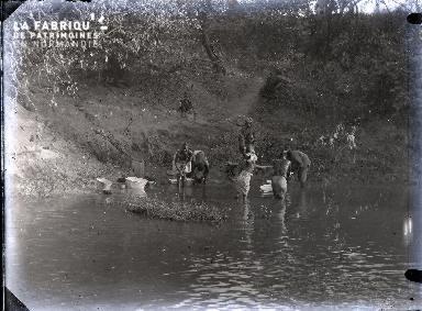 Afrique-Hommes se lavant au bord d'un lac