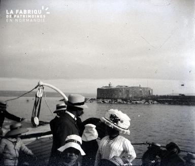 Bateau et ses passagers, derrière un fort en bout de jetée
