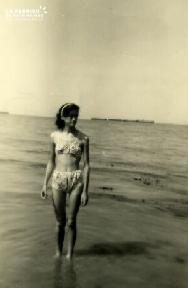 Femme posant sur une plage du Débarquement après guerre (épave)
