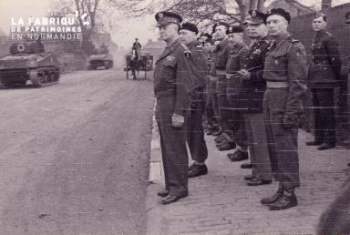 Groupe de militaires regardant passer les chars dans la rue