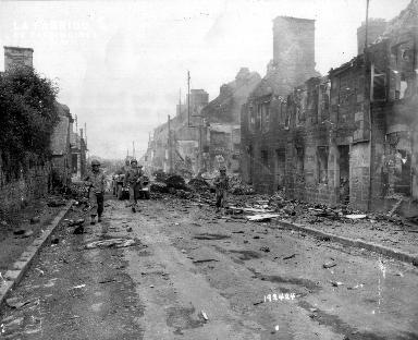 Progression de soldats américains dans les ruines de Juvigny le Tertre