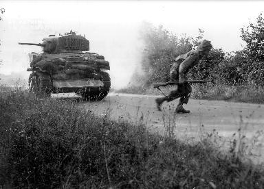 Le 8 août 1943, un soldat américain traverse une route près d'un char de combat.