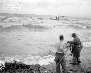 A l'aide dune corde, deux soldats essaient d'aider les naufragés (secteur Omaha)
