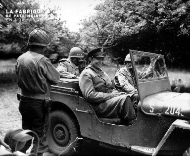 Le 4 juillet 1944 à Huanville, le général Eisenhower sourit à bord d'une jeep américaine.