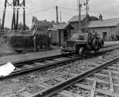 Jeep sur la voie ferrée Paris-Cherbourg (Lison), à son bord des soldats américains.