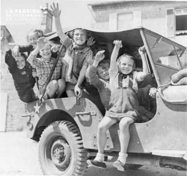 Enfants à bord d'une jeep américaine