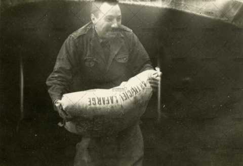 Soldat français portant un sac de ciment