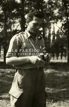 Soldat fumant sa pipe et réglant son appareil photo en Algérie