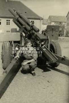 Soldat français posant devant un canon de 105 mm