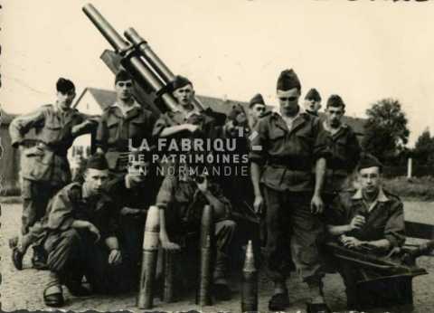 Soldat français posant devant un canon et ses munitions
