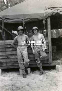 Le 8 juillet 1944, soldats américains, GI's (rangers) prennent la pose torse nu, accoudés à un baraquement.