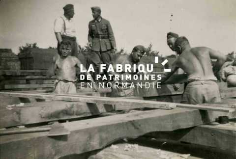 Charpentiers de la Wehrmacht lors de travaux de construction d'un quai de déchargement proche de la gare Bayeux